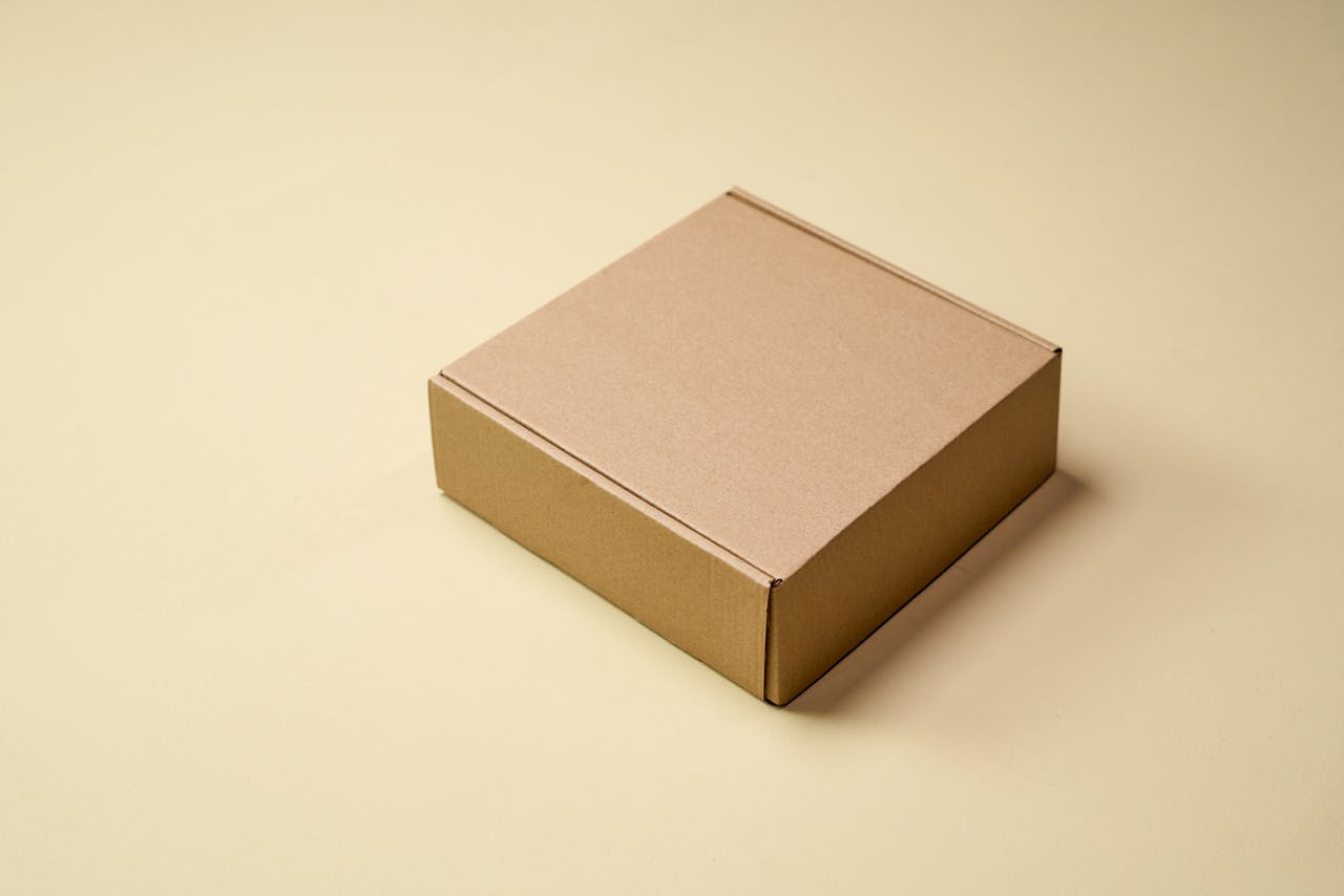 about-us Simple cardboard box displayed on a neutral surface, ideal for product packaging visuals.